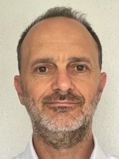 Head and shoulders photo of Nick Marley, a white male in his 50s with brown eyes wearing a white shirt; he has short brown hair and a facial hair. 